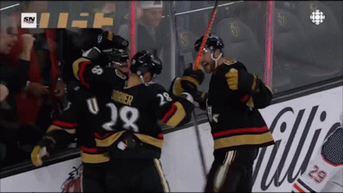 A Hockey Player With The Number 28 On His Jersey Is Being Hugged By His Teammates GIF