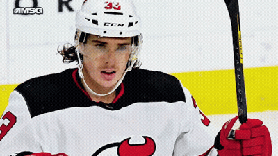 A Hockey Player With The Number 33 On His Helmet Is Holding A Hockey Stick GIF