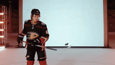 A Hockey Player With The Number 4 On His Jersey Is Holding A Hockey Stick GIF