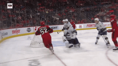 A Hockey Player With The Number 52 On His Jersey Is Skating Around The Ice GIF