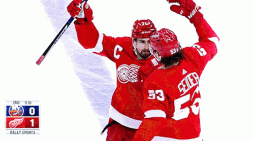 A Hockey Player With The Number 53 On His Jersey Is Hugging Another Player GIF