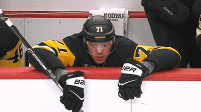 A Hockey Player With The Number 71 On His Helmet Sits On The Bench GIF