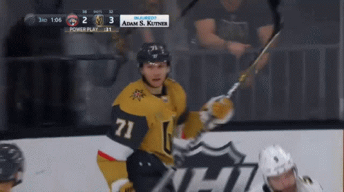 A Hockey Player With The Number 71 On His Jersey Holds A Hockey Stick GIF
