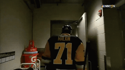 A Hockey Player With The Number 71 On His Jersey Walks Through A Doorway GIF