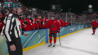 A Hockey Player With The Number 8 On His Jersey Stands On The Ice Surrounded By His Teammates GIF
