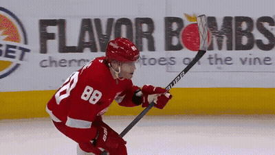 A Hockey Player With The Number 88 On His Jersey Is Holding A Hockey Stick GIF