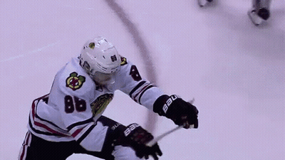 A Hockey Player With The Number 88 On His Jersey Is Holding A Hockey Stick On The Ice . GIF