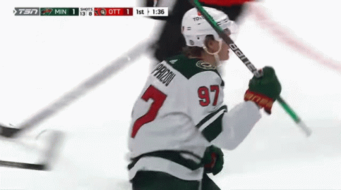 A Hockey Player With The Number 97 On His Jersey Is Holding A Hockey Stick . GIF