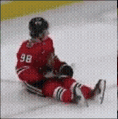 a hockey player with the number 98 on his back is laying on the ice