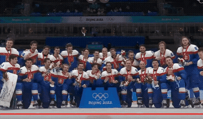 A Hockey Team Poses For A Photo In Front Of A Sign That Says ' Beijing 2022 ' GIF