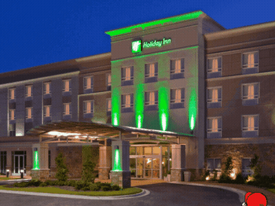 A Holiday Inn Hotel With Green Lights On The Front Of It GIF