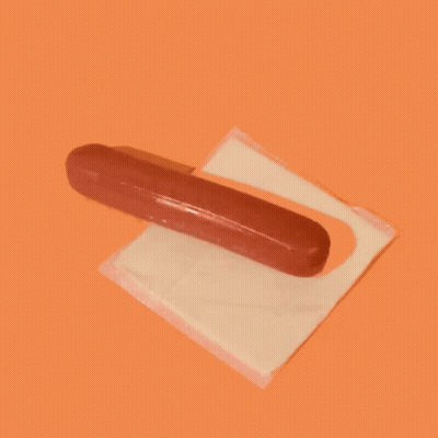 A Hot Dog Sitting On Top Of A Slice Of Cheese GIF
