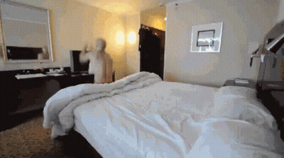 a hotel room with a large bed and a basketball hoop on the wall