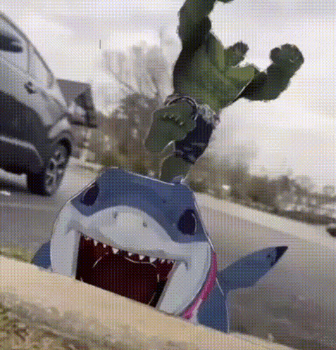 A Hulk Is Standing On Top Of A Shark On The Sidewalk GIF