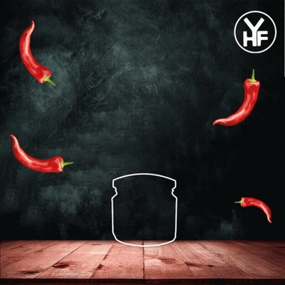 A Jar Of Chilli Paste Sits On A Wooden Table With Red Peppers Around It GIF