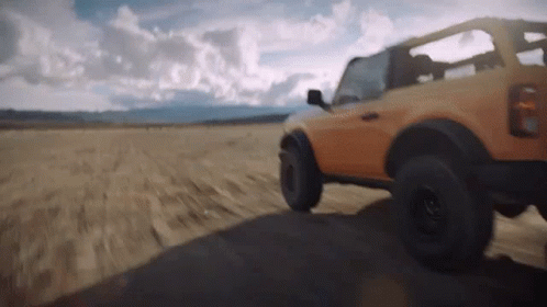 A Jeep Is Driving Down A Dirt Road In The Desert GIF