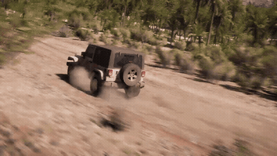 A Jeep Is Driving On A Dirt Road In The Desert . GIF