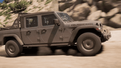 A Jeep Rubicon Is Driving Down A Sandy Road GIF