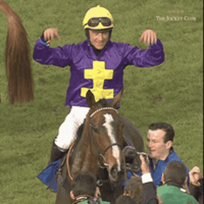 A Jockey Wearing A Purple Shirt With A Yellow Cross On It GIF