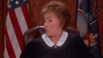 A Judge Is Sitting In A Courtroom With Her Hands Outstretched . GIF