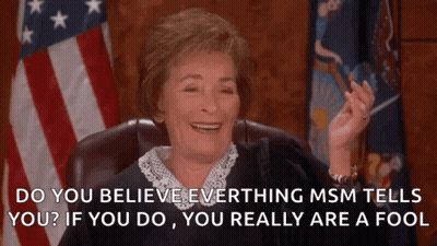 A Judge Is Smiling In Front Of An American Flag While Sitting In A Chair . GIF