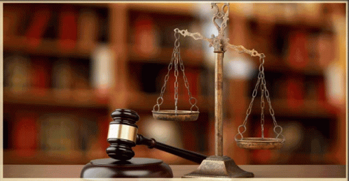 A Judge 'S Gavel And Scales Of Justice Are On A Table GIF