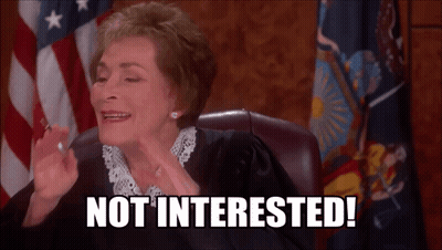 A Judge Sitting In Front Of An American Flag With The Words Not Interested On Her Face GIF