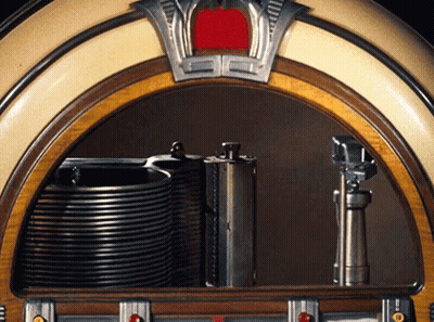 A Jukebox With A Stack Of Cds On The Shelf GIF