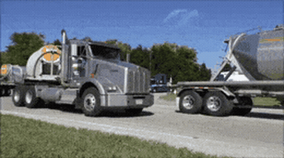 A Kenworth Semi Truck Is Driving Down A Road GIF