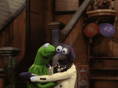 A Kermit The Frog And A Muppet Standing Next To Each Other With Balloons In The Background GIF