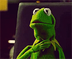 A Kermit The Frog Is Sitting In Front Of A Computer Screen GIF