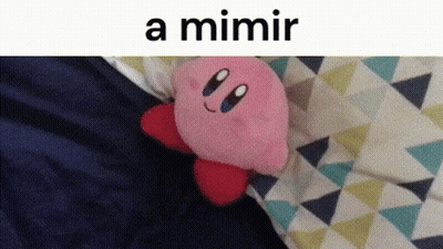 A Kirby Stuffed Animal Is Laying On A Bed Next To A Triangle Patterned Blanket . GIF