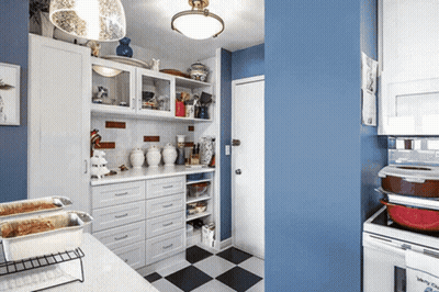 A Kitchen With Blue Walls And White Cabinets Has A Checkered Floor GIF