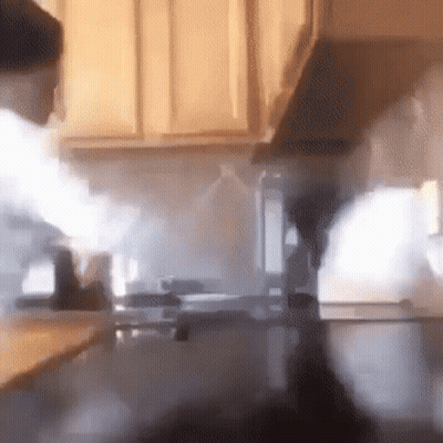 A Kitchen With Smoke Coming Out Of The Hood GIF