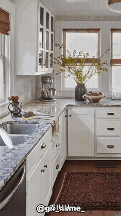 A Kitchen With White Cabinets And Granite Counter Tops And A Rug GIF