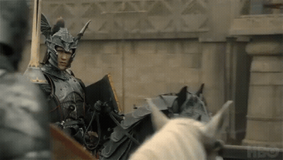 A Knight In Armor Is Riding A Horse Drawn Carriage . GIF