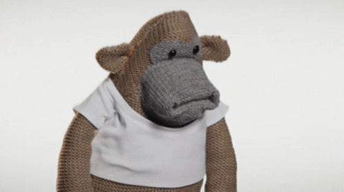 A Knitted Monkey Wearing A White Shirt GIF