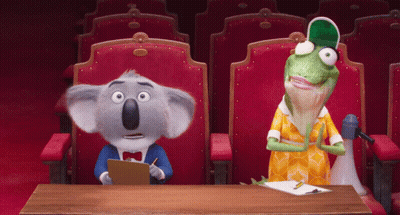 A Koala Bear And A Lizard Sit At A Table In A Theater GIF