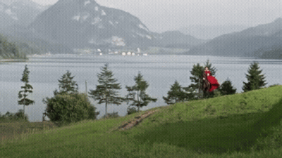 A Lake With Mountains In The Background And Trees On The Shore GIF