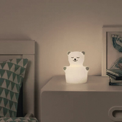 A Lamp In The Shape Of A Polar Bear Sits On A Nightstand GIF