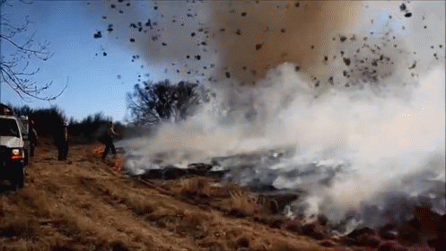 A Large Amount Of Smoke Is Coming Out Of A Fire In A Field GIF
