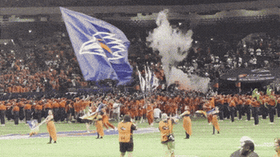 A Large Blue Flag With An Eagle On It Is Being Displayed GIF