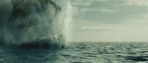 A Large Body Of Water Is Being Sprayed By A Large Rock GIF