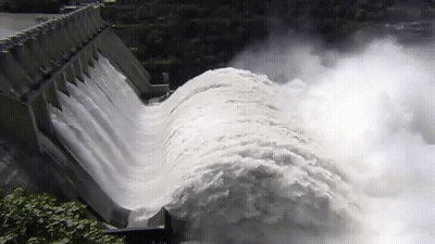 A Large Body Of Water Is Coming Down A Dam Wall GIF
