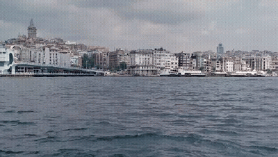 A Large Body Of Water Surrounded By Buildings With A City In The Background GIF
