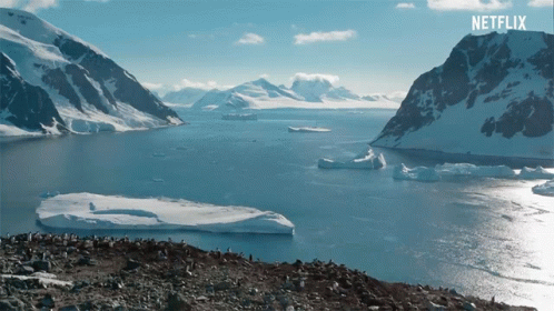 A Large Body Of Water With Mountains In The Background And A Netflix Logo On The Bottom GIF