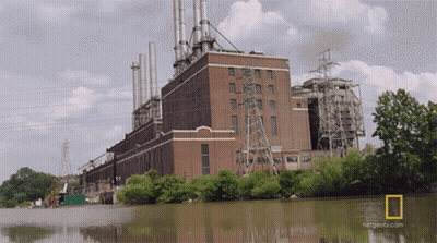 A Large Brick Building Next To A Body Of Water With A National Geographic Logo GIF