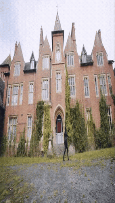 A Large Brick Building With A Clock On The Front GIF