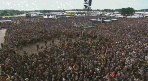 A Large Crowd Of People Are Gathered In A Field With A Sign That Says ' S.f. ' On It GIF
