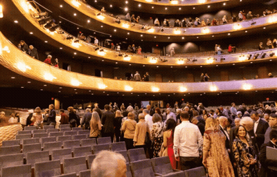 A Large Crowd Of People Are Gathered In A Large Theater GIF